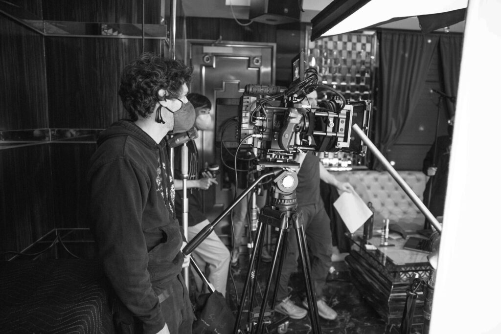 Behind the scenes on a lit studio set with full camera and grip rigging.