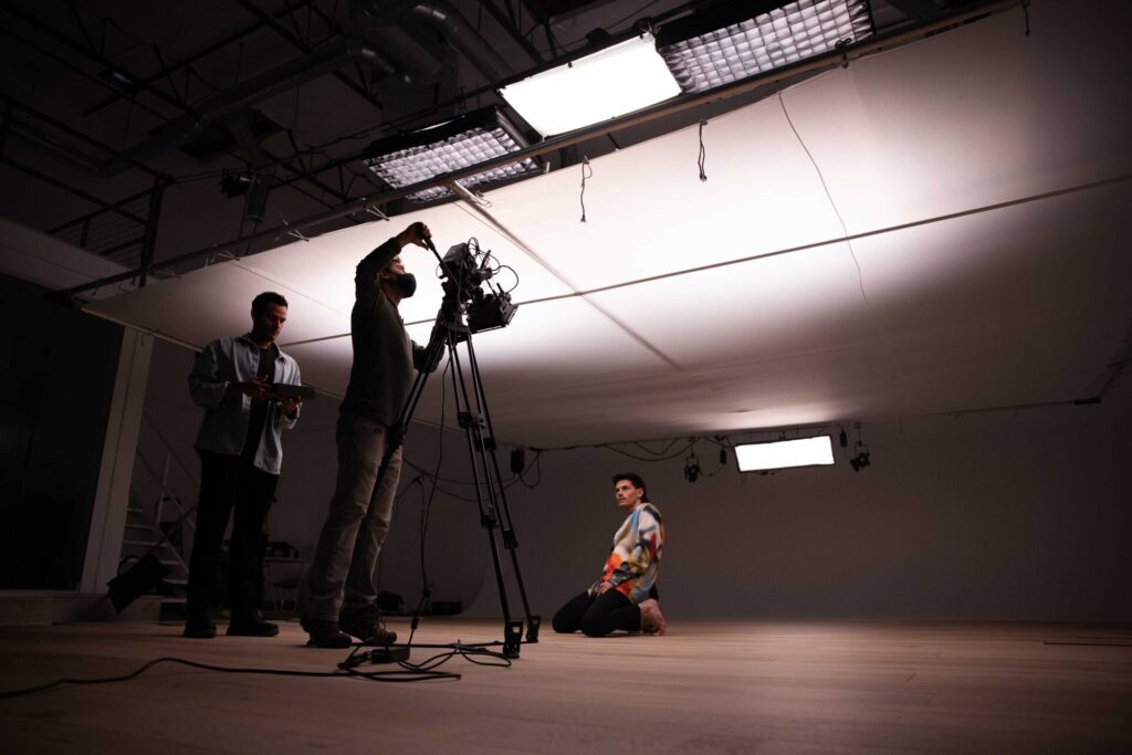 Wide view of a New Evolution Video film set with cinema camera, lighting, and crew.