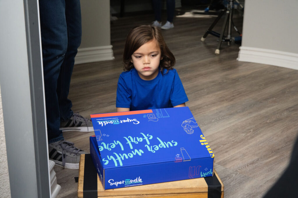 A young actor on set beside a clapperboard during a New Evolution Video shoot.